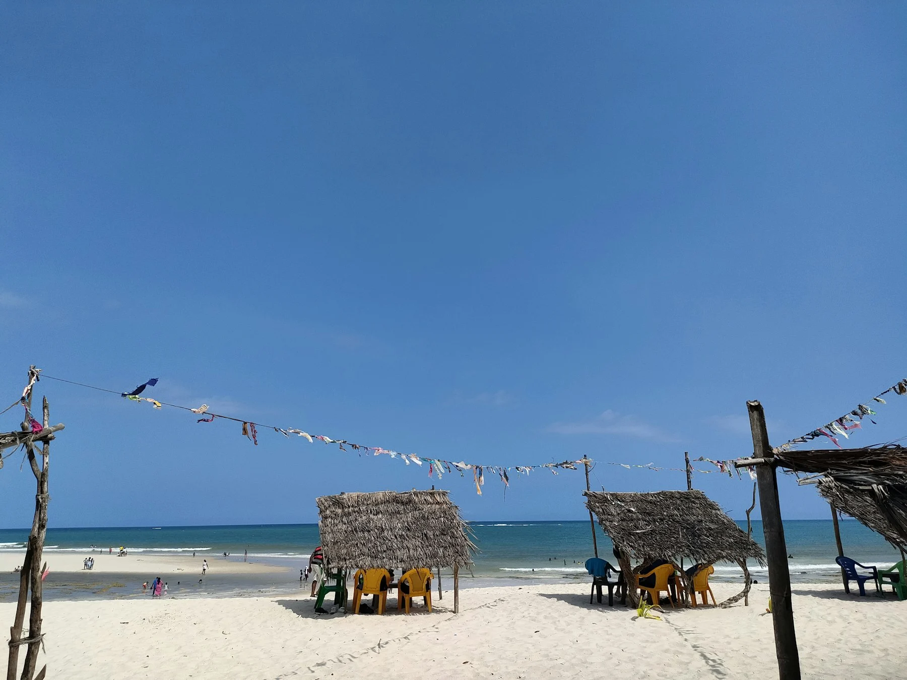 Sun loungers and thatched umbrellas on a white sand beach in Diani, Kenya